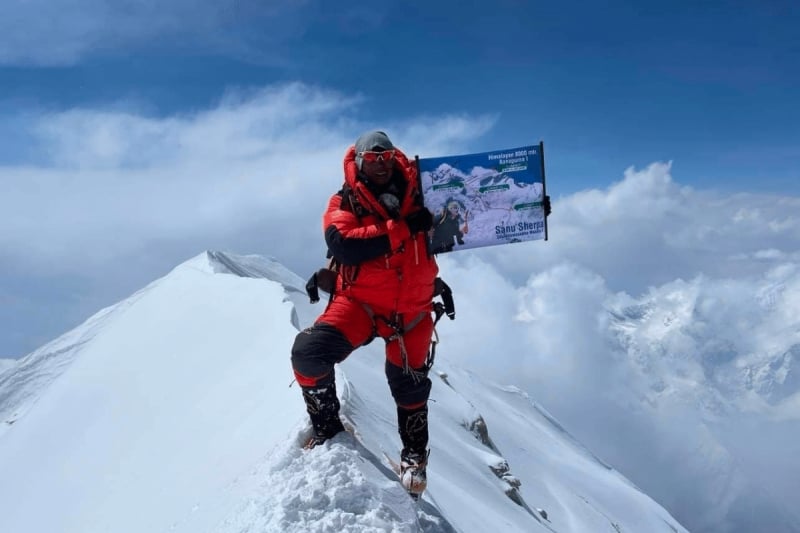 shanu sherpa on a mountain summit