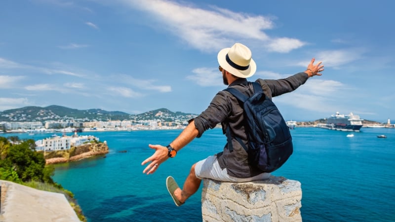 guy overlooking the sea with his arms wide open