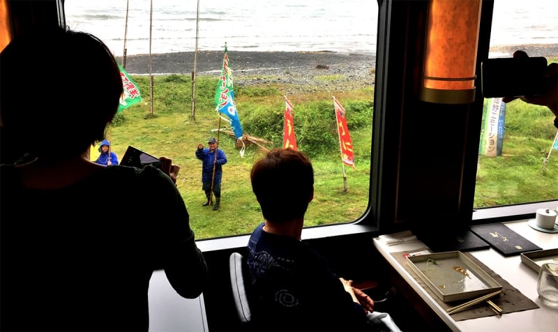 volunteers waving flags from outside the train