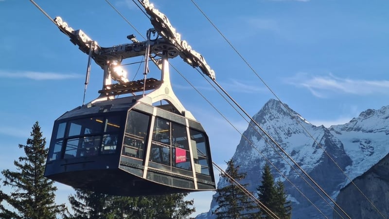 the schilthornbahn cable car with a peak of the bernese alps in the background