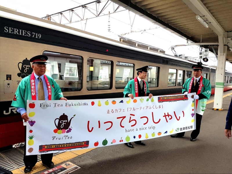 train staff holding a welcome banner