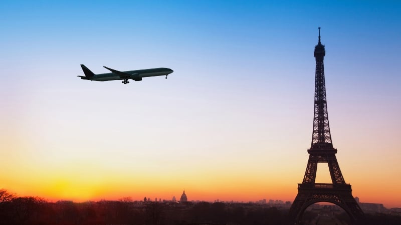 a plane flying over paris, france with the eiffel tower