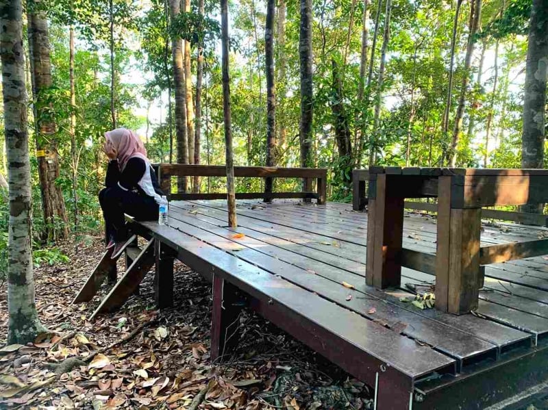 a girl sitting on a bench on gunung arong