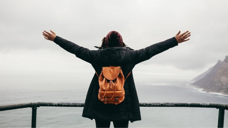 arms spread wide overlooking the sea