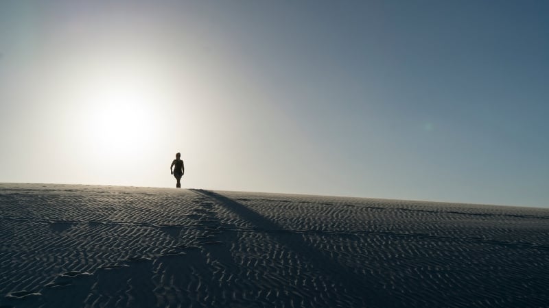 person standing on a sand dune