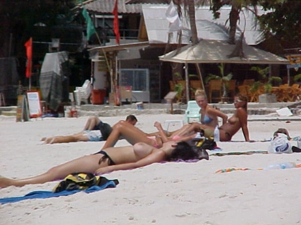 Hundreds of nudist people running into the sea naked