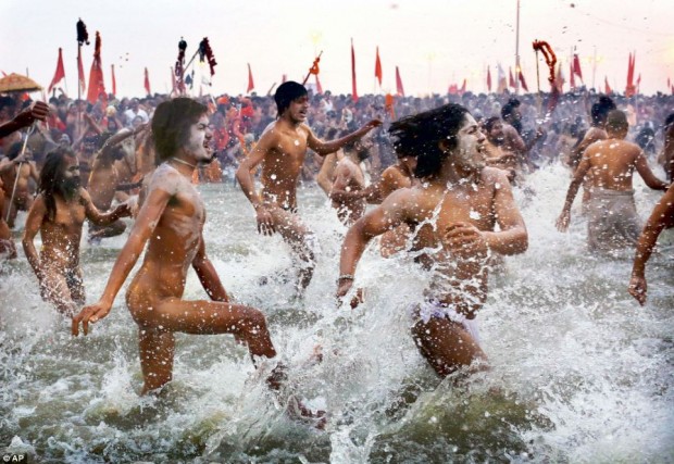 Hundreds of nudist people running into the sea naked