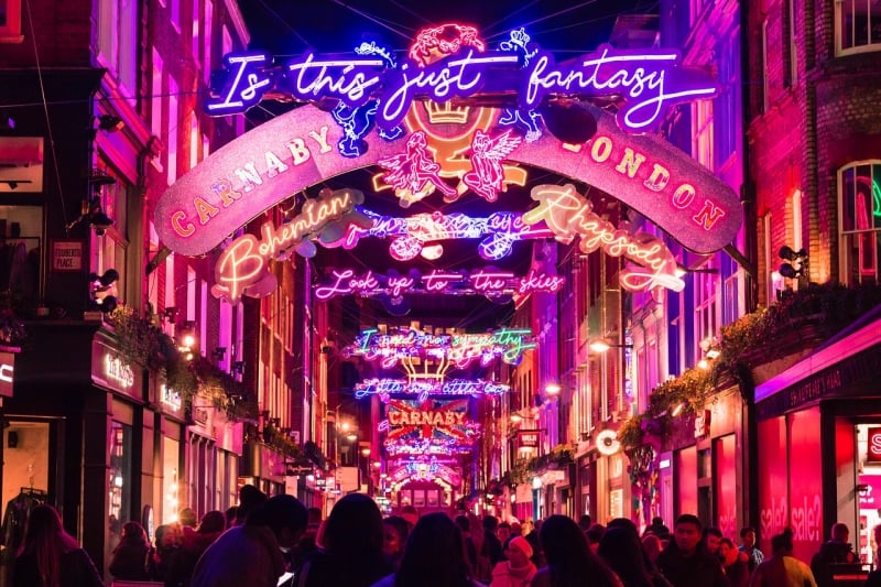 People Walking Under Lightbulb Lights In Carnaby Street