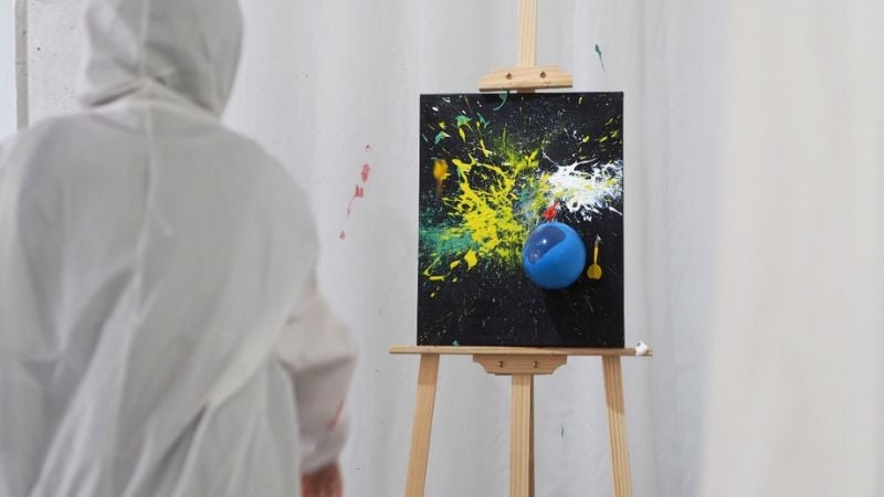throwing balloon of paint on canvas