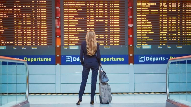 woman in an airport looking at departure timings
